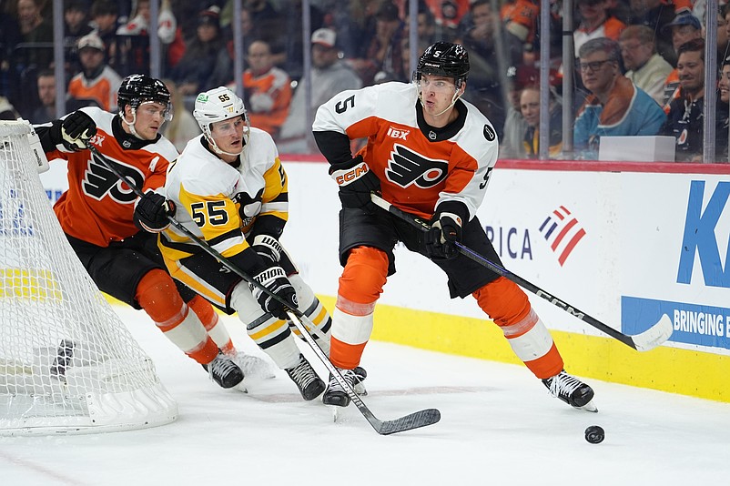 Oct 28, 2025; Philadelphia, Pennsylvania, USA; Philadelphia Flyers defenseman Egor Zamula (5) chases the puck against Pittsburgh Penguins center Noel Acciari (55) in the second period at Xfinity Mobile Arena. Mandatory Credit: Kyle Ross-Imagn Images