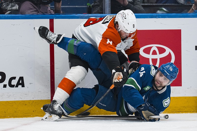 Dec 30, 2025; Vancouver, British Columbia, CAN; Philadelphia Flyers defenseman Cam York (8) checks Vancouver Canucks forward Jake DeBrusk (74) in the second period at Rogers Arena. Mandatory Credit: Bob Frid-Imagn Images