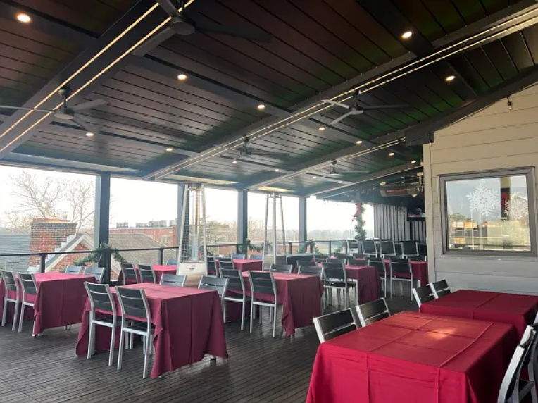The new rooftop bar and lounge features a louvered pergola roof and motorized retractable screens to permit seating during inclement weather. (Courtesy of Joe Wade)