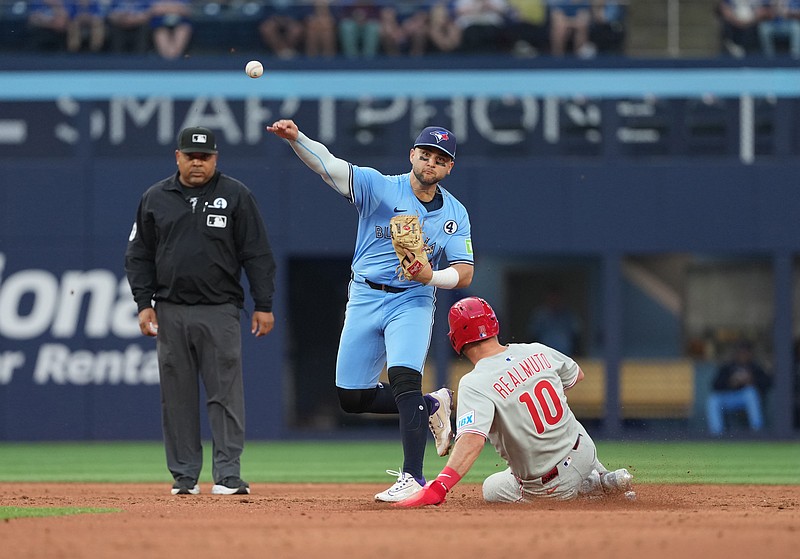 Jun 3, 2025; Toronto, Ontario, CAN; Toronto Blue Jays shortstop Bo Bichette (11) tags out Philadelphia Phillies catcher J.T. Realmuto (10) at second base during the third inning at Rogers Centre. Mandatory Credit: Nick Turchiaro-Imagn Images