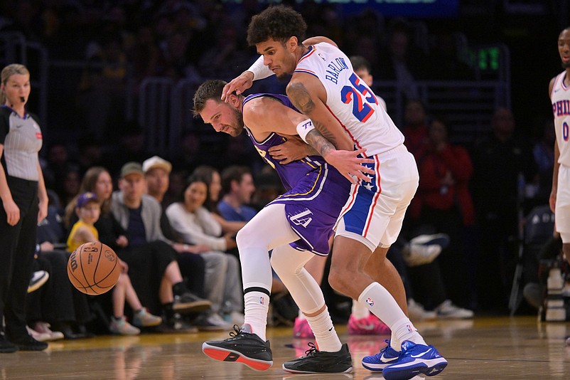 Feb 5, 2026; Los Angeles, California, USA;  Los Angeles Lakers guard Luka Doncic (77) and Philadelphia 76ers forward Dominick Barlow (25) scramble for a loose ball in the first half at Crypto.com Arena. Mandatory Credit: Jayne Kamin-Oncea-Imagn Images