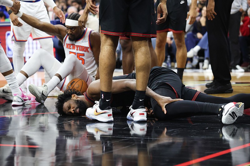 Jan 24, 2026; Philadelphia, Pennsylvania, USA; Philadelphia 76ers center Joel Embiid (21) grabs his leg after falling to the floor on a play against the New York Knicks during the fourth quarter at Xfinity Mobile Arena. Mandatory Credit: Bill Streicher-Imagn Images