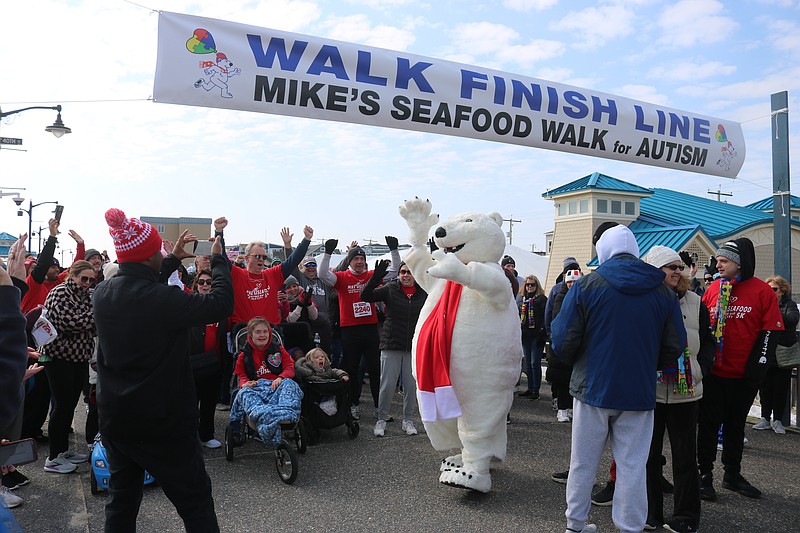 The Coca-Cola polar bear character exhorts the crowd at the start of the Mike's Seafood Run-Walk for Autism fundraiser.