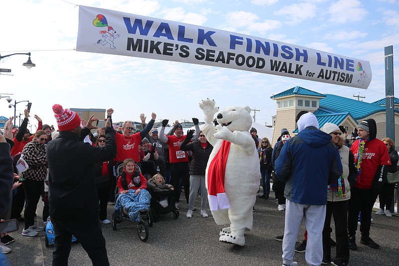 The Coca-Cola polar bear character exhorts the crowd at the start of the Mike's Seafood Run-Walk for Autism fundraiser.