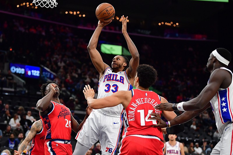 Feb 2, 2026; Inglewood, California, USA; Philadelphia 76ers forward Jabari Walker (33) shoots against Los Angeles Clippers guard Kobe Brown (24) and center Yanic Konan Niederhauser (14) during the second half at Intuit Dome. Mandatory Credit: Gary A. Vasquez-Imagn Images