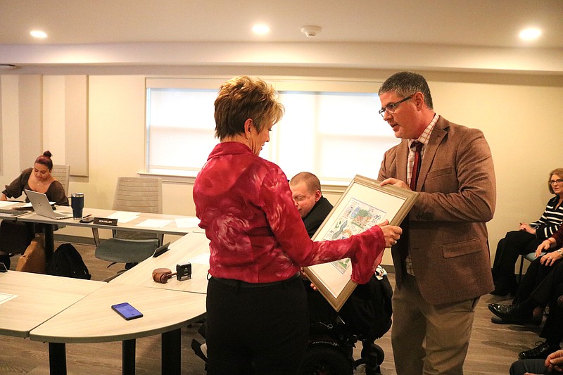 Ocean City Housing Authority Executive Director Ron Miller presents Jacqueline Jones with a collage honoring her career in public housing.
