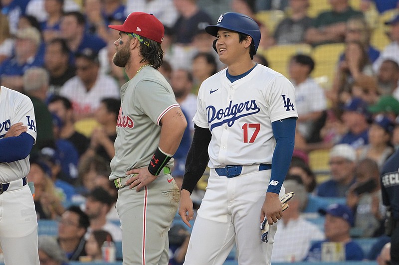 Aug 7, 2024; Los Angeles, California, USA;  Los Angeles Dodgers designated hitter Shohei Ohtani (17) laughs with Philadelphia Phillies first baseman Bryce Harper (3) as they wait for a replay in the first inning at Dodger Stadium. Mandatory Credit: Jayne Kamin-Oncea-USA TODAY Sports