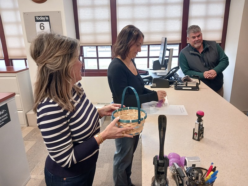 Councilman Tony Polcini watches as City Clerk Melissa Rasner draws plastic eggs from a basket held by her assistant, Nicole Driscoll.