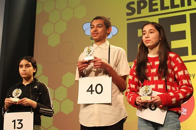 Isaac Geremew, center, will represent the area at the national bee. Sonia Dragos, left, of Northfield, was second, with Camden's Alina Perez Garcia third. (WHYY)