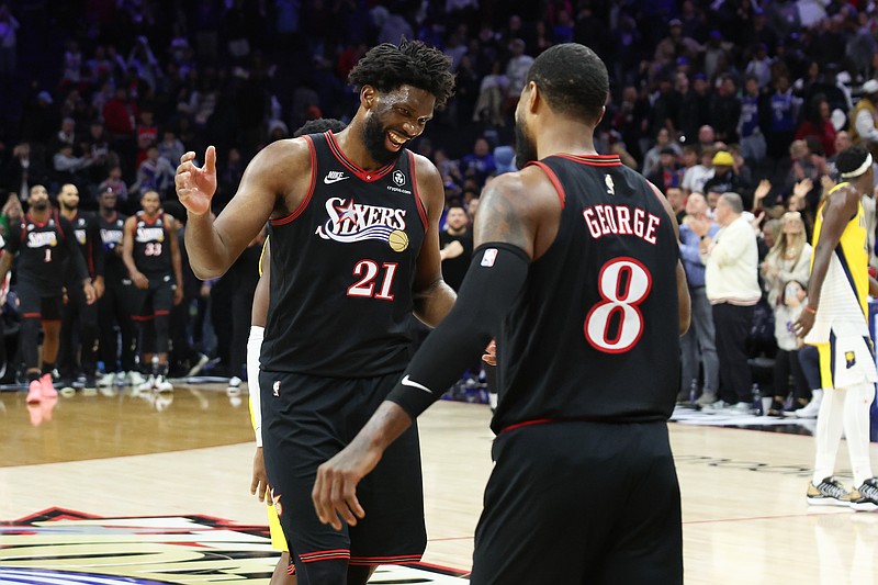 Dec 12, 2025; Philadelphia, Pennsylvania, USA; Philadelphia 76ers center Joel Embiid (21) reacts with forward Paul George (8) after a victoryagainst the Indiana Pacers during at Xfinity Mobile Arena. Mandatory Credit: Bill Streicher-Imagn Images