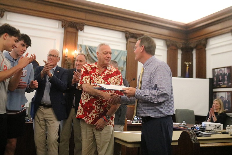 Coach John Bruno accepts the proclamation from Mayor Jay Gillian amid applause from his players and City Council members.