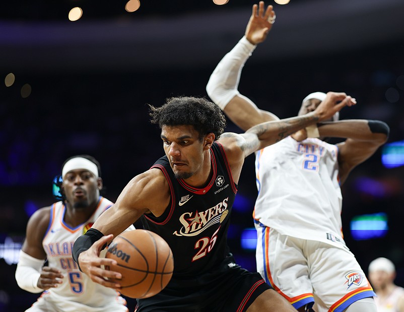 Mar 23, 2026; Philadelphia, Pennsylvania, USA; Philadelphia 76ers forward Dominick Barlow (25) controls the ball against Oklahoma City Thunder guard Shai Gilgeous-Alexander (2) and guard Luguentz Dort (5) during the second quarter at Xfinity Mobile Arena. Mandatory Credit: Bill Streicher-Imagn Images