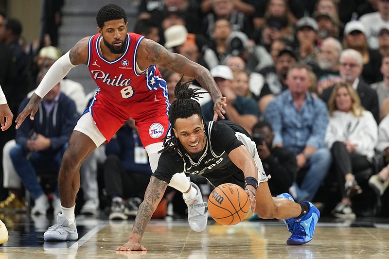 Apr 6, 2026; San Antonio, Texas, USA; San Antonio Spurs guard Stephon Castle (5) reaches for a loose ball ahead of Philadelphia 76ers forward Paul George (8) during the second half at Frost Bank Center. Mandatory Credit: Scott Wachter-Imagn Images