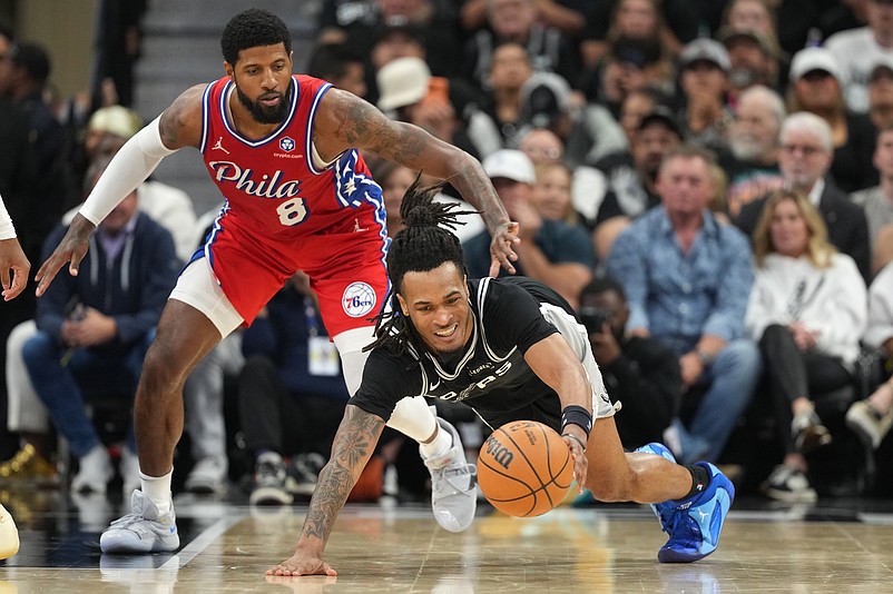 Apr 6, 2026; San Antonio, Texas, USA; San Antonio Spurs guard Stephon Castle (5) reaches for a loose ball ahead of Philadelphia 76ers forward Paul George (8) during the second half at Frost Bank Center. Mandatory Credit: Scott Wachter-Imagn Images