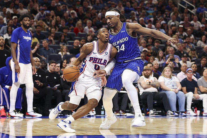 Jan 9, 2026; Orlando, Florida, USA; Philadelphia 76ers guard Tyrese Maxey (0) drives to the basket past Orlando Magic center Wendell Carter Jr. (34) in the second quarter at Kia Center. Mandatory Credit: Nathan Ray Seebeck-Imagn Images