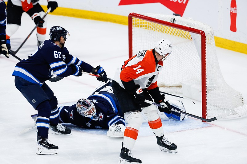 Apr 11, 2026; Winnipeg, Manitoba, CAN;  Philadelphia Flyers forward Sean Couturier (14) scores on Winnipeg Jets goalie Eric Comrie (1) during the third period at Canada Life Centre. Mandatory Credit: Terrence Lee-Imagn Images