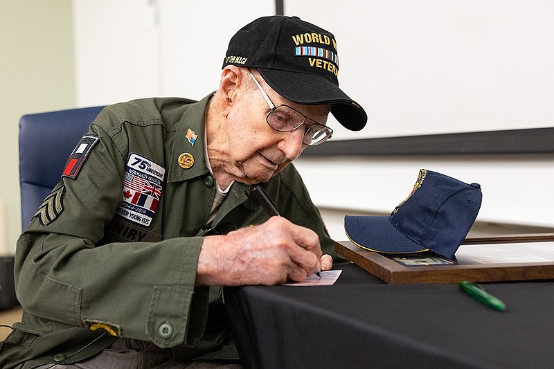 Andrew 'Tim' Kiniry, of Minotola, signs a baseball card of himself after addressing the audience at Stockton University. (Stockton University)
