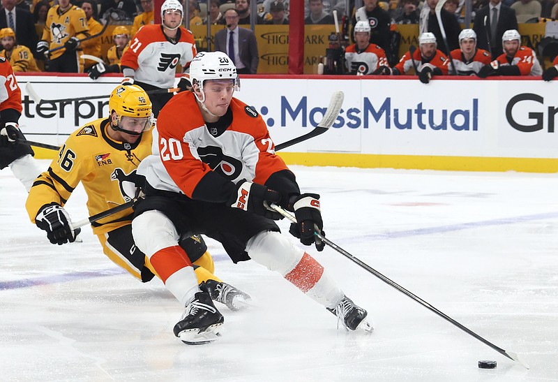 Apr 27, 2026; Pittsburgh, Pennsylvania, USA;  Philadelphia Flyers left wing Alex Bump (20) moves the puck against Pittsburgh Penguins center Blake Lizotte (46) during the first period in game five of the first round of the 2026 Stanley Cup Playoffs at PPG Paints Arena. Mandatory Credit: Charles LeClaire-Imagn Images