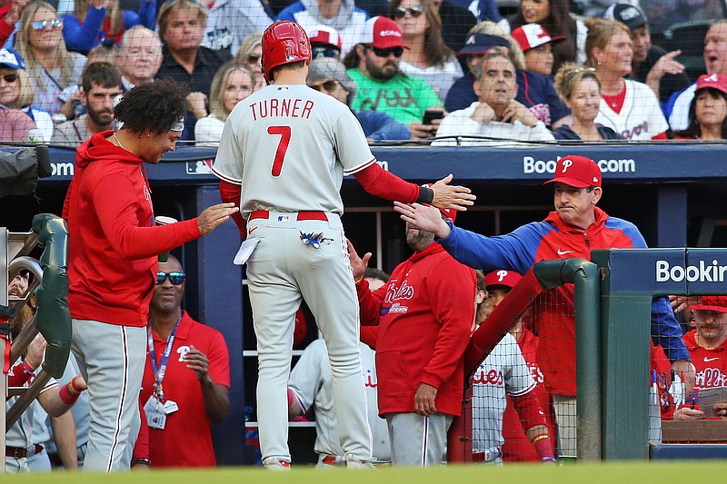 Oct 9, 2023; Cumberland, Georgia, USA; Philadelphia Phillies shortstop Trea Turner (7) celebrates with manager Rob Thomson (59) after scoring a run during the first inning against the Atlanta Braves in game two of the NLDS for the 2023 MLB playoffs at Truist Park. Mandatory Credit: Brett Davis-USA TODAY Sports
