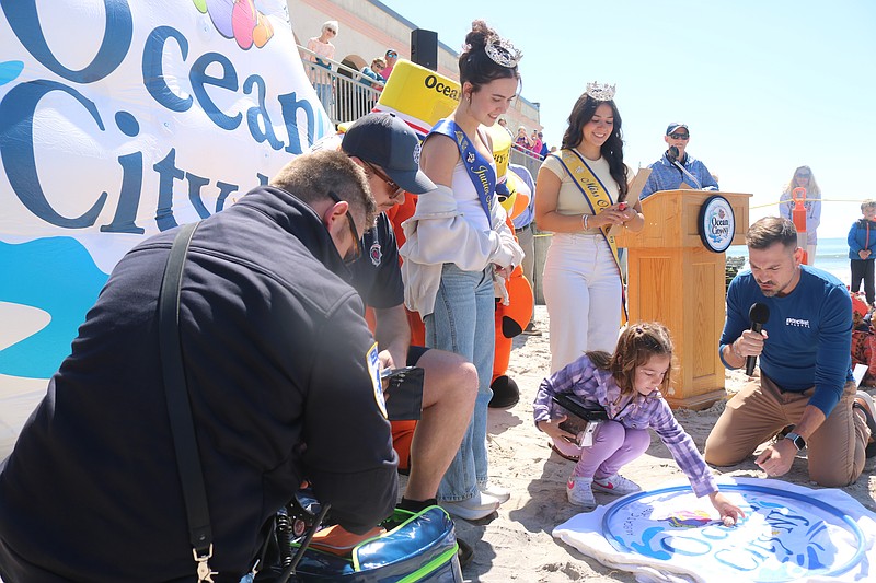 Brynn Flatley points to the hermit crab on a towel, while host "Nor’easter” Nick Pittman, microphone in hand, describes the moment Martin Z. Mollusk "sees" his shadow.