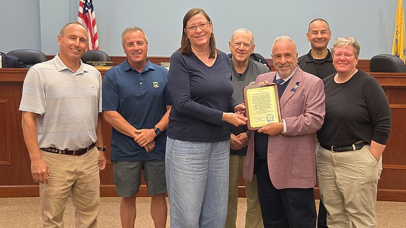Katherine Custer receives a commemorative plaque honoring her service from Mayor Leonard Desiderio and members of City Council. (Photo courtesy of Sea Isle City)