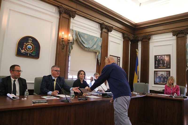 Ocean City resident Tom Sirianni hands City Council President Terry Crowley Jr. a copy of the petition opposing the cellphone tower planned at 3308 Bay Ave.
