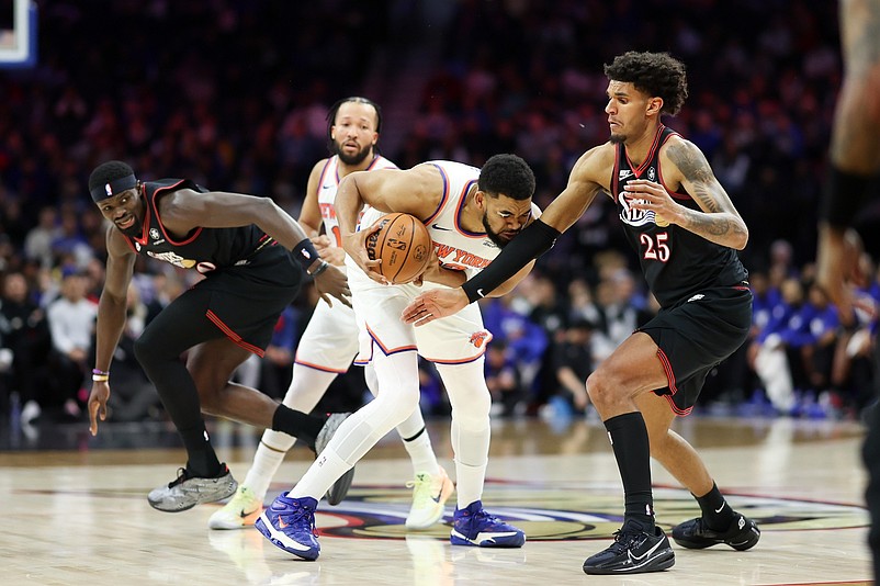 Feb 11, 2026; Philadelphia, Pennsylvania, USA; New York Knicks center Karl-Anthony Towns (32) holds the ball against Philadelphia 76ers forward Dominick Barlow (25) during the first half at Xfinity Mobile Arena. Mandatory Credit: Bill Streicher-Imagn Images