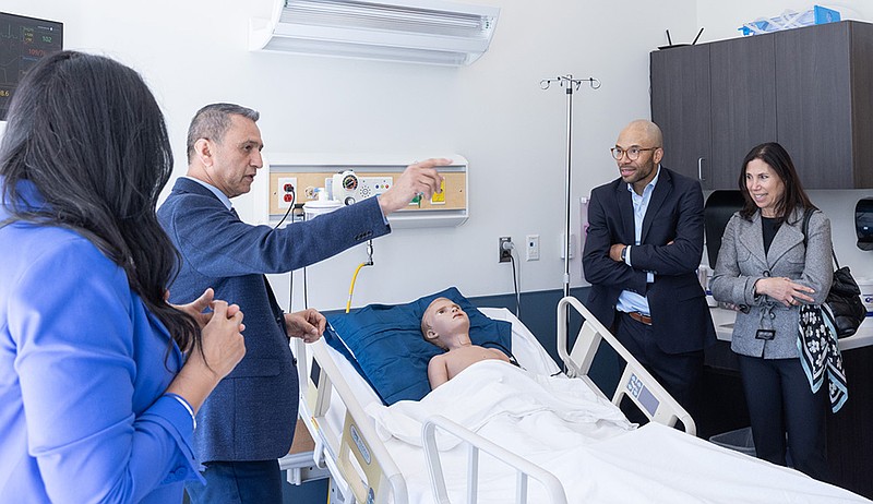 Ali Moradi, interim dean of Stockton University's School of Health Sciences, talks about one of the nursing simulation stations during a tour with Johnson & Johnson officials.