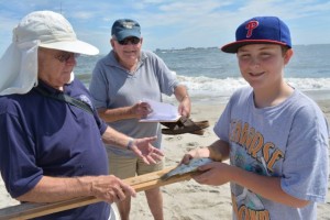 Ocean City Fishing Club members Bruce Balderson, left, and Bob Roth measure and record a youngster’s catch during last year’s Boys and Girls Surf Fishing Tournament.