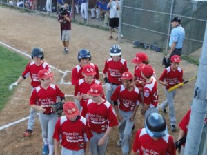 The boys surround Joe Gallagher as he hits a home run on just the third at-bat of the game.