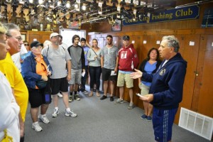 With rows of surf rods overhead, trustee Dan Ladik, right, welcomes visitors into the Ocean City Fishing Club’s clubhouse during the 2014 Open House. 