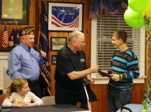 VFW member Joe Walters  (center) recognizes Jacyn Pisieczko, 14, as Post Commander Mike Morrissey looks on. On Friday, the post gave Pisieczko's family a trip to Disney World.