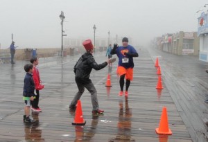 Kindergarten teacher and race organizer Carrie Merritt greets a Pi Day Run finisher with a whipped-cream pie.