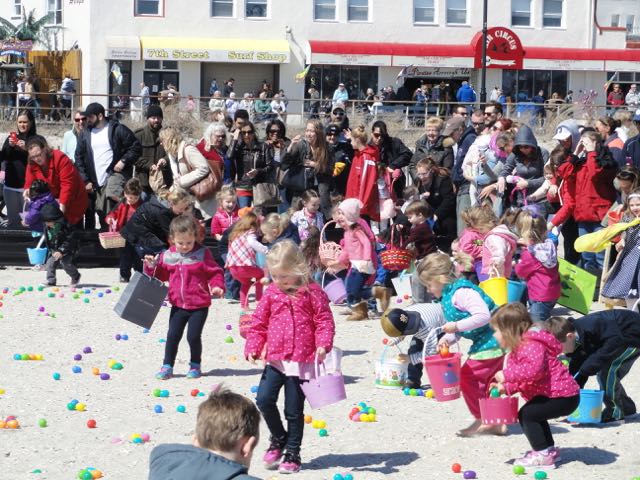 Three-year-olds search for plastic eggs in the annual Easter Egg Hunt on the beach between 11th and 14th streets on Saturday, April 4.