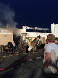 Firefighters remove charred inventory from 7th Street Surf Shop on the Boardwalk in Ocean City on Saturday night.  Credit: Eric Levai