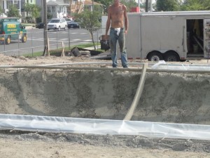 Wooden molds run along a metal coping and help shape the concrete bowl.