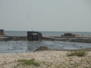 A last bit of "slurry" (a mixture of sand and water) spills from a pipeline running down the beach from 55th Street to 50th Street.