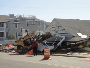 A bulldozer clears debris from Asbury Avenue after the collapse of the abandoned Palermo's Family Market during demolition on Thursday morning.