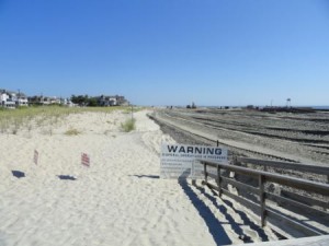 Excavating equipment is moving sand to double the width of an existing dune at 58th Street.