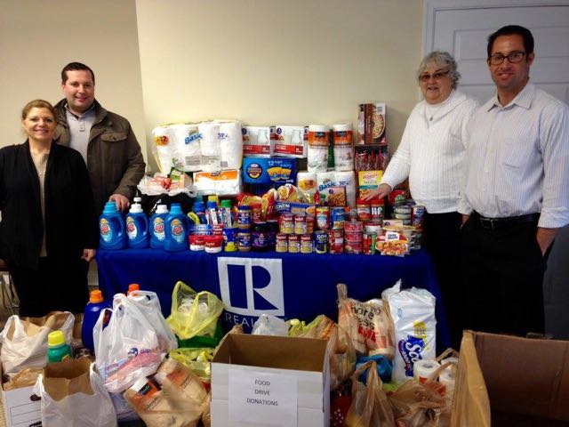 2015 Photo of the many generous donations and the Car Caravan drivers: Gloria Votta and Damon Bready from RE/MAX at The Shore, Dottie Cianci from the Ecumenical Food Cupboard, Pete Madden from Berkshire Hathaway Fox & Roach Realtors.