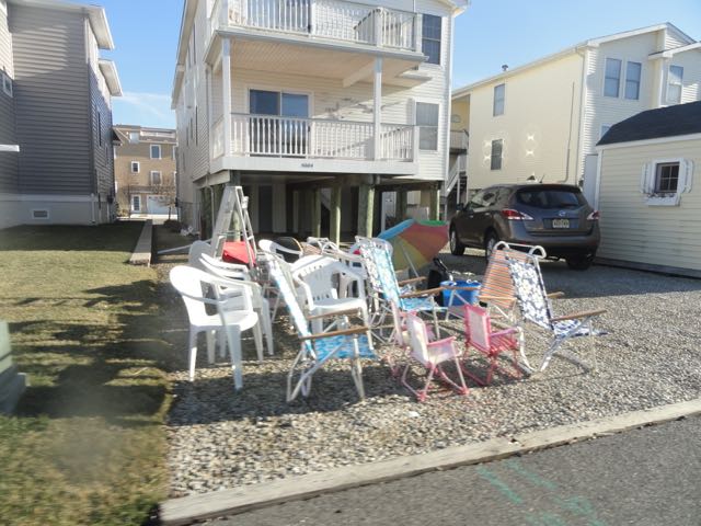 Residents dry out beach equipment that was flooded in ground-level storage spaces.