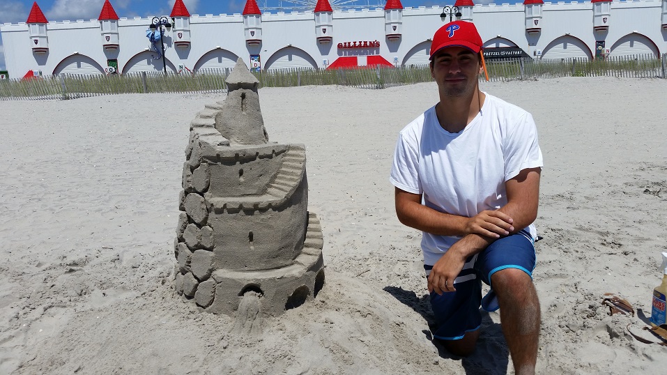 Frank Siderio, of West Chester, Pa., winner of the sand sculpting contest, shows off his elaborately crafted medieval castle.