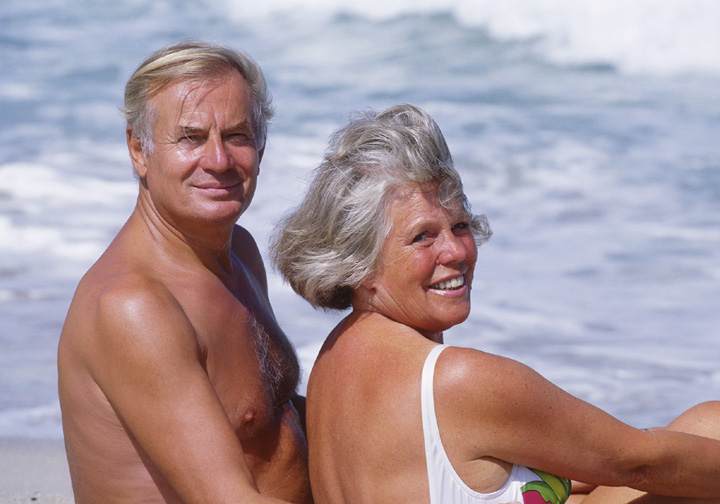 Seniorenpaar, sitzen am Strand, Halbportraet