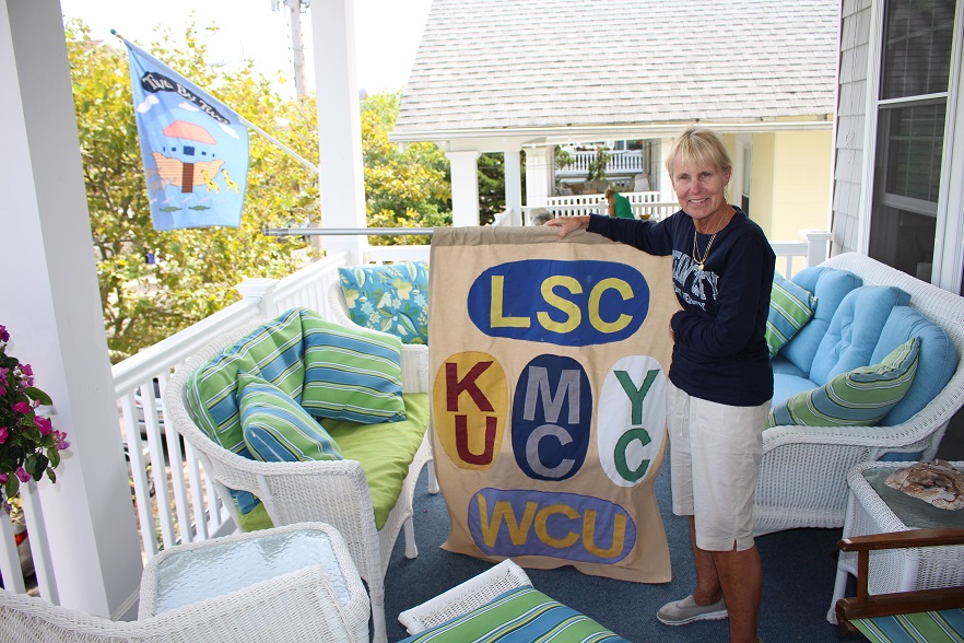 Pam Moran shows of the custom college flag she made to commemorate the schools attended by her children.