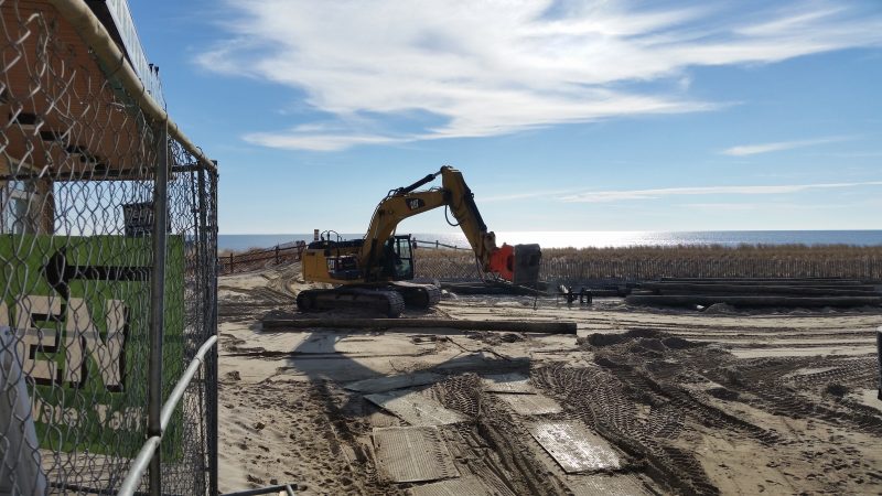 A piece of heavy construction equipment clears out an area underneath the Boardwalk for new piles to be installed.