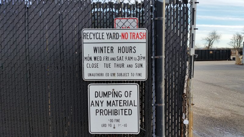 The recycling yard is surrounded by a covered fence.