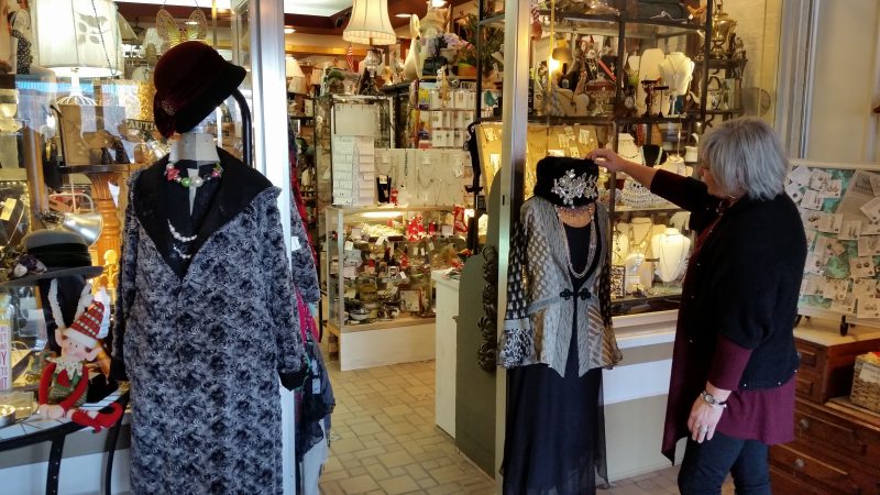 Saleswoman Helen Taylor adjusts a mannequin at the doorway of one shop.