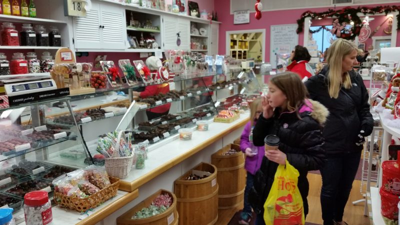 Customers marvel over the array of chocolate candies in the display cases.