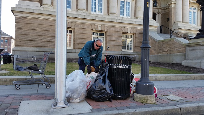 Councilman Keith Hartzell, who worked with local churches and the city to organize the cleanup about 10 years ago, sorts through some of the litter collected near City Hall on Monday.