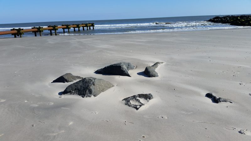 Rocks are exposed on the eroded beach at Fifth Street.